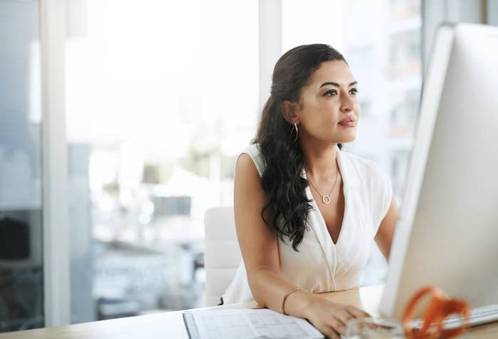 A woman works on her computer in an office building