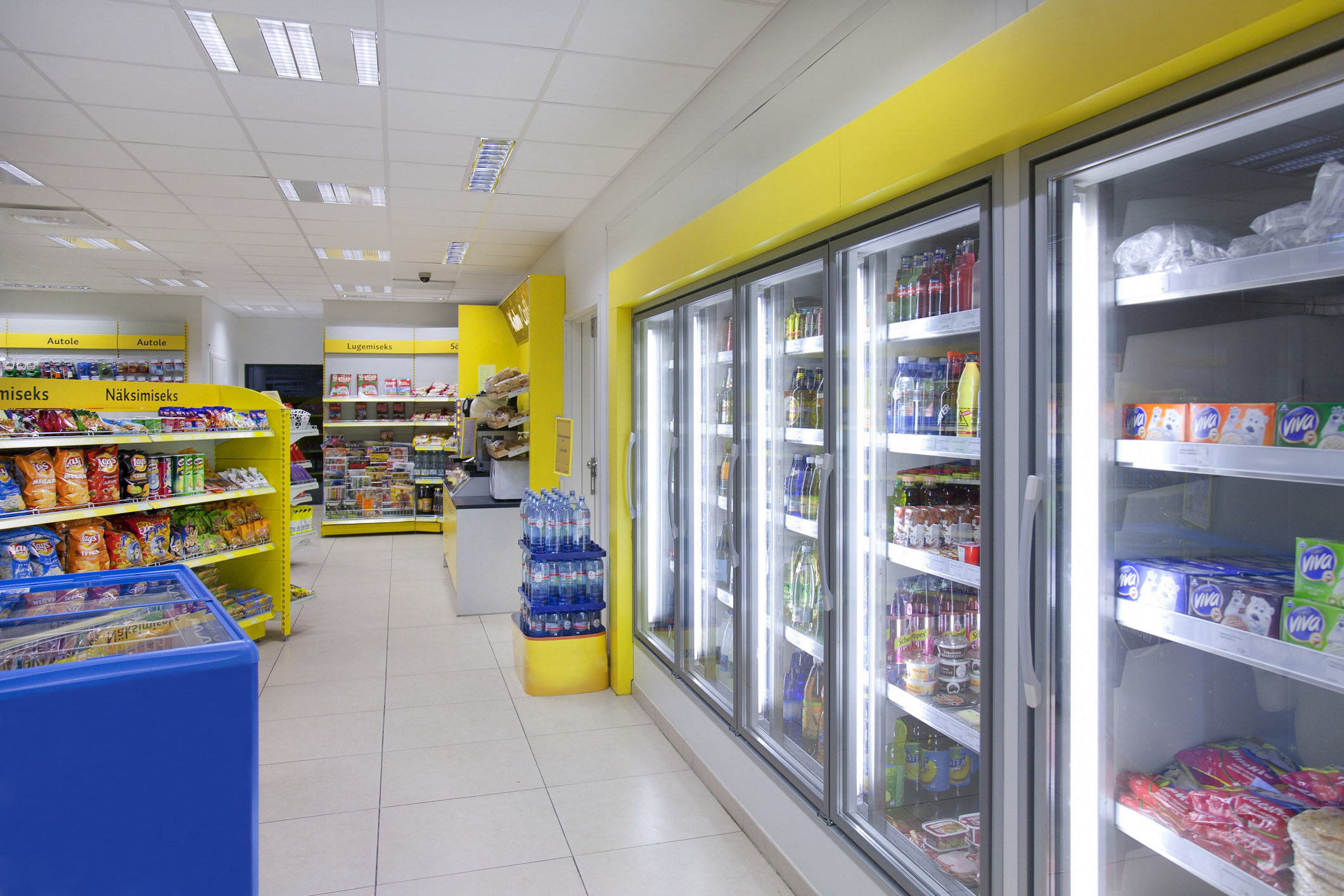 A convenience store&#x27;s refrigerated section and snack aisle
