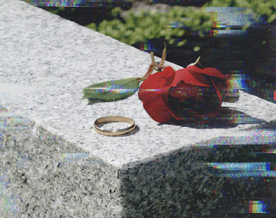 a ring and a rose on a tombstone
