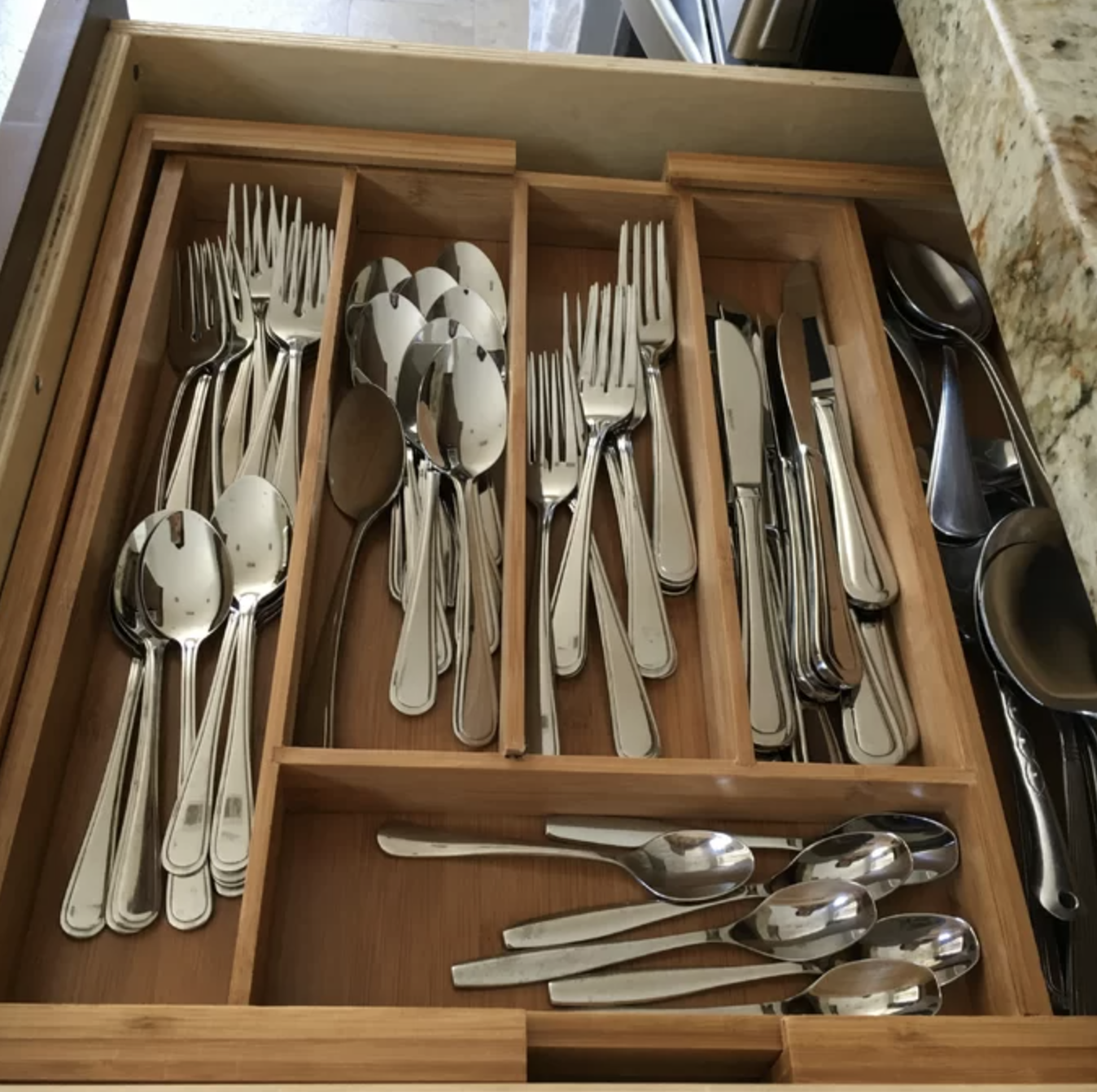 the wooden drawer organizer with utensils in it