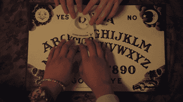 people playing with a Ouija board