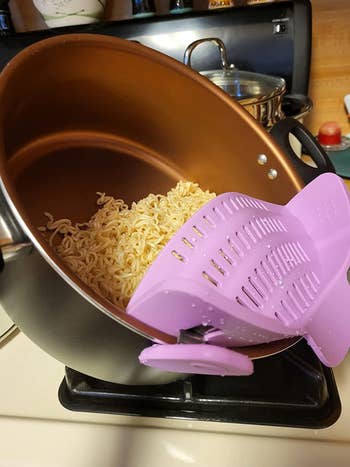 a reviewer photo of someone using the strainer in purple