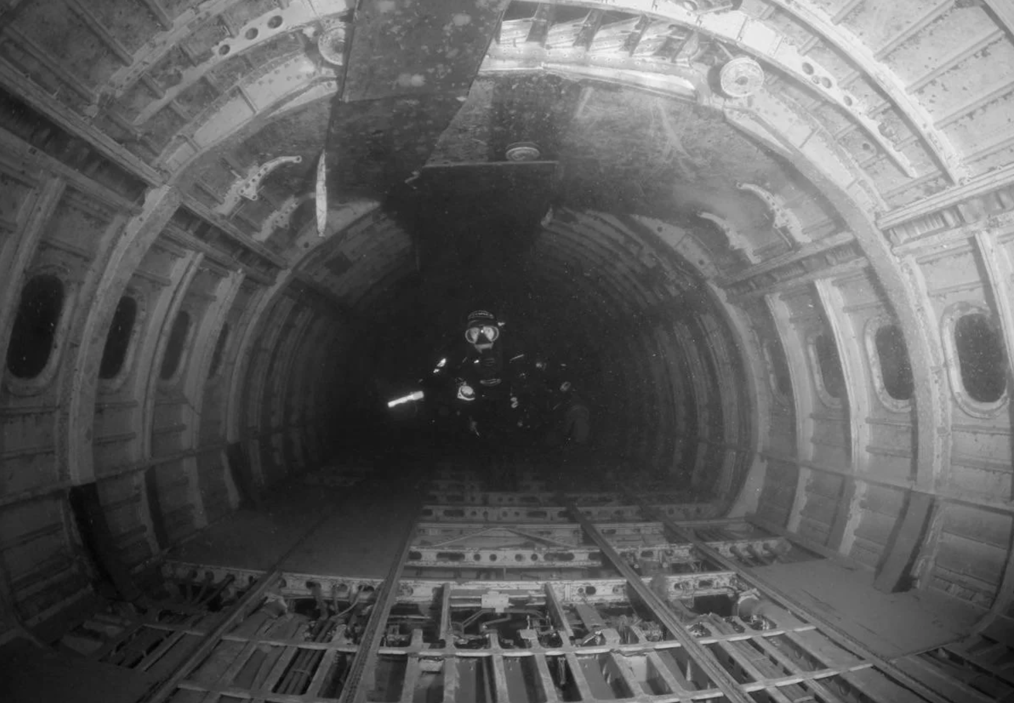 A diver swims through the inside of a plane full of water