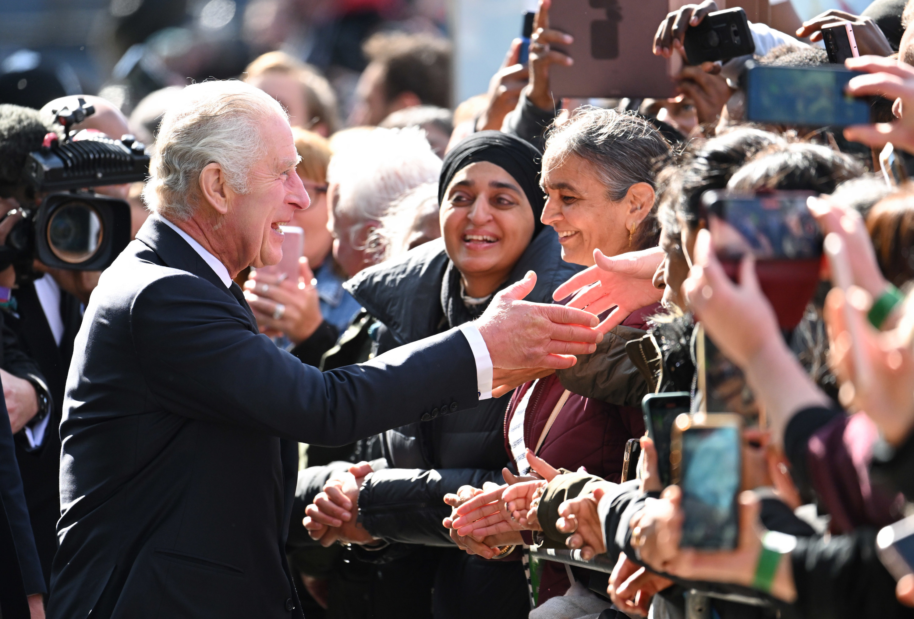 King Charles III greets members of the public queueing along the river Thames.