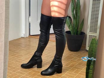 reviewer wearing black over-the-knee boots