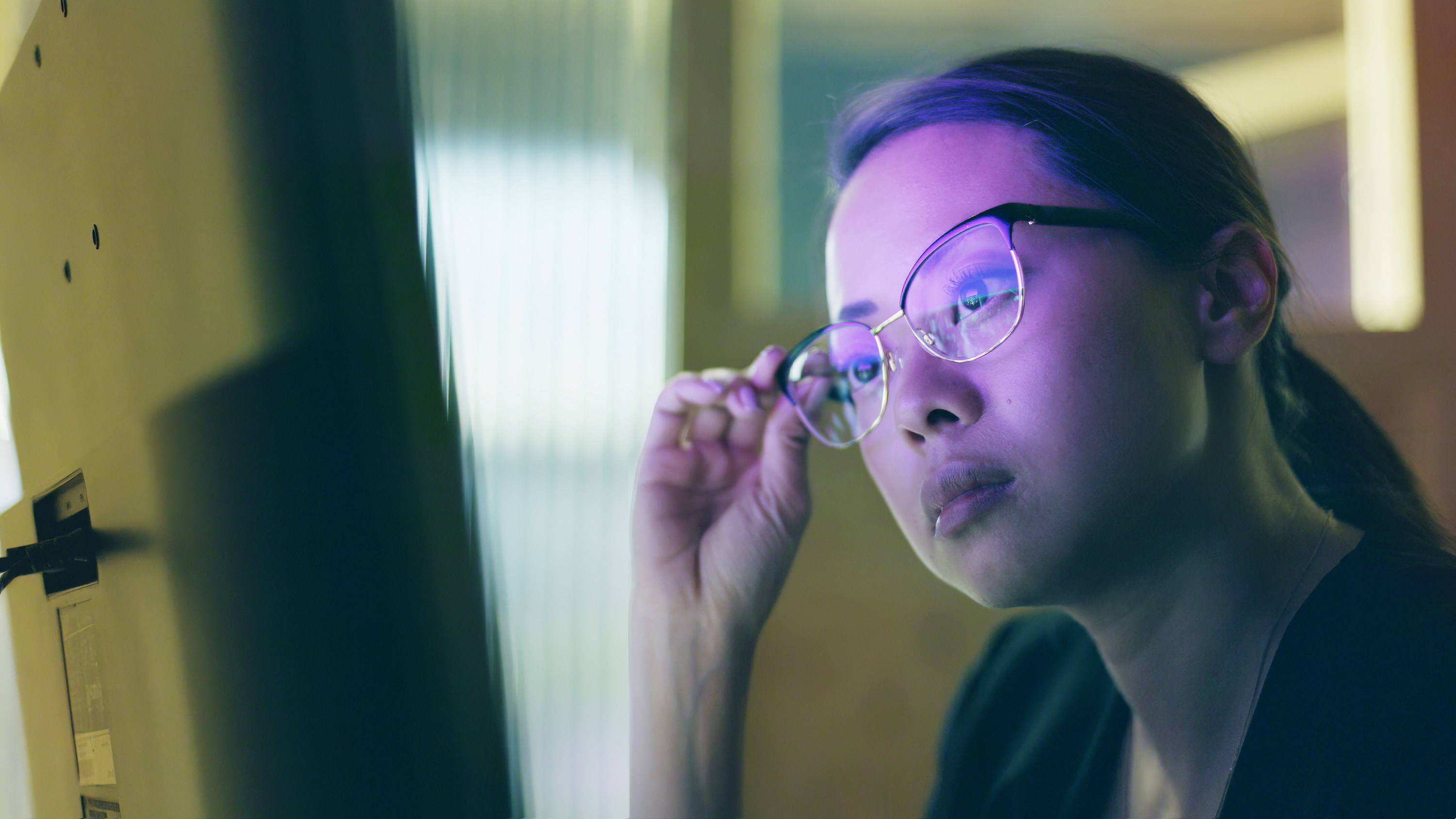 A woman stares at a computer screen