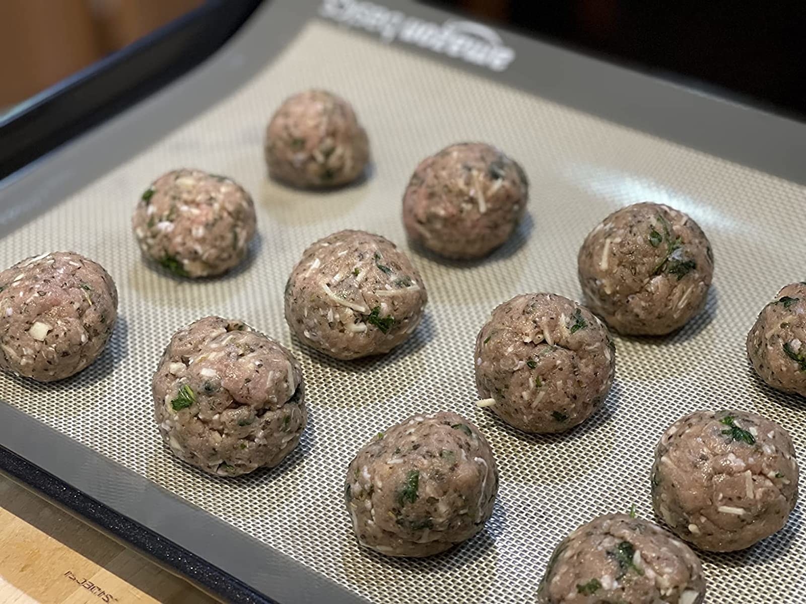 Reviewer image of meatballs on baking sheet lined with silicone mat