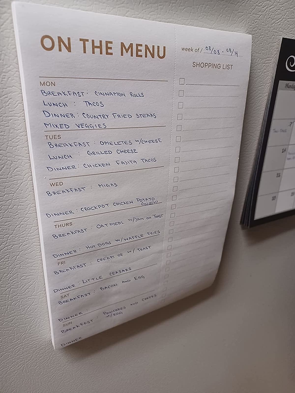 Reviewer image of filled in meal planner on the fridge