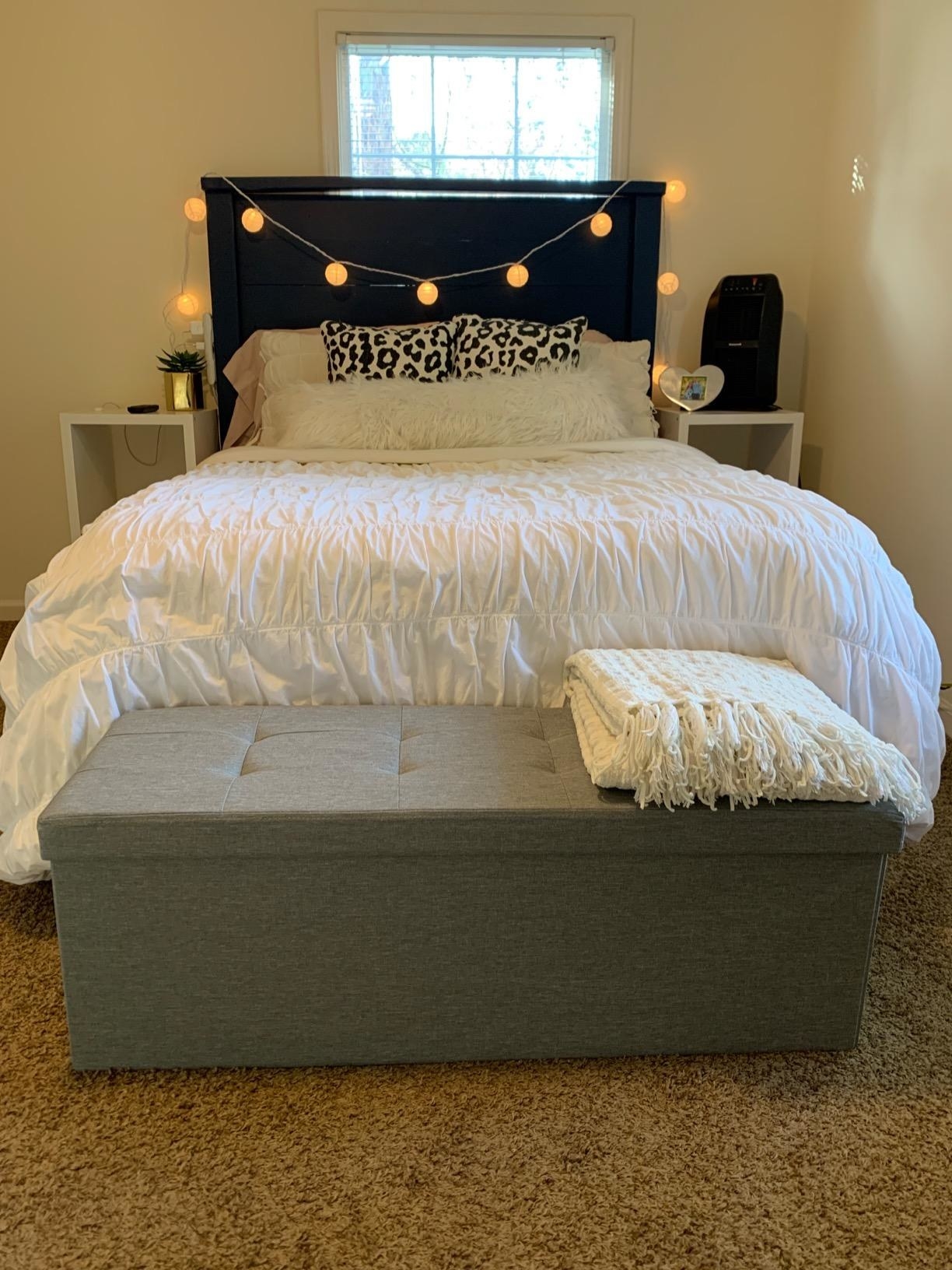 Reviewer image of gray ottoman at the end of the bed in a bedroom