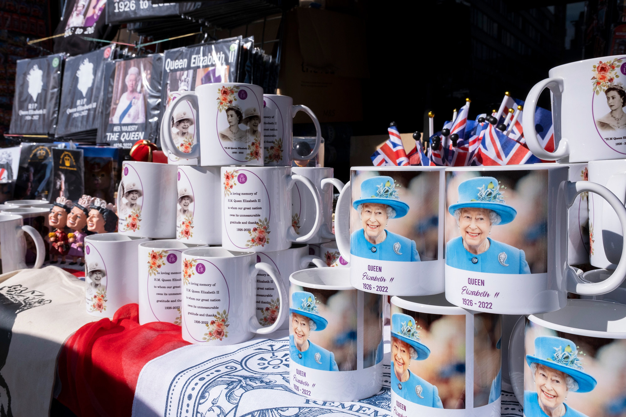 Mugs showing the smiling Queen with &quot;Queen Elizabeth II&quot; on them and the dates 1926–2022