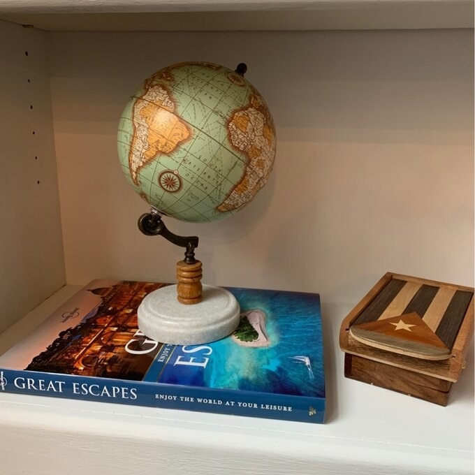 reviewer&#x27;s picture of the mini globe on a bookshelf