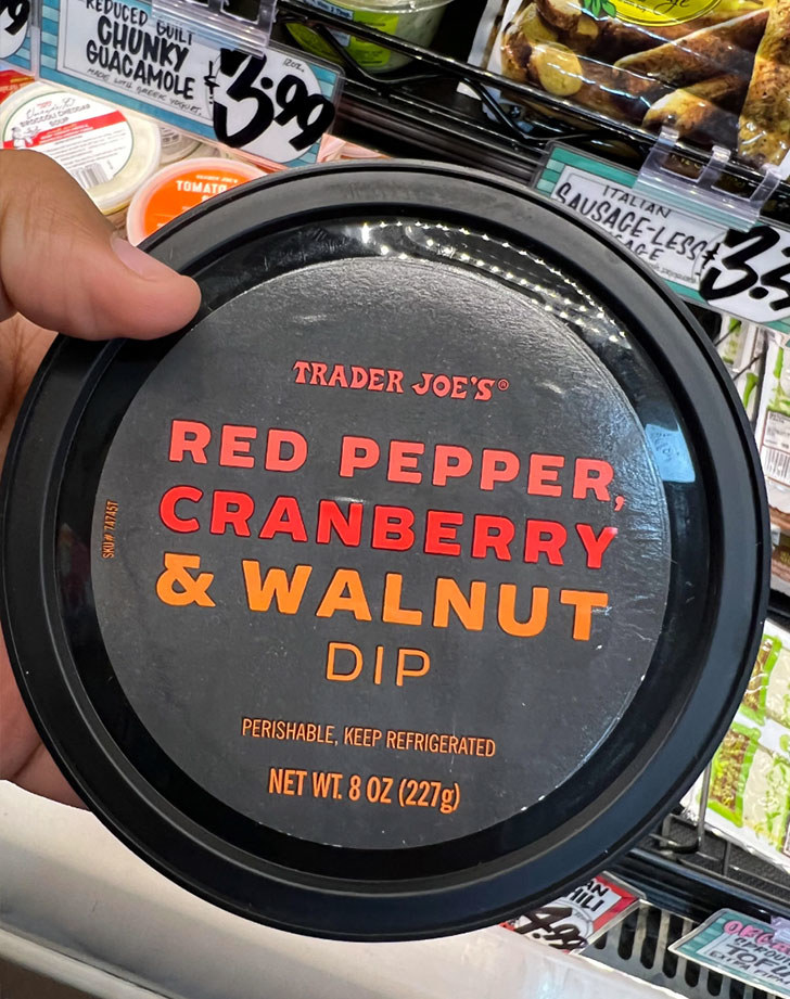 A container of red pepper cranberry and walnut dip