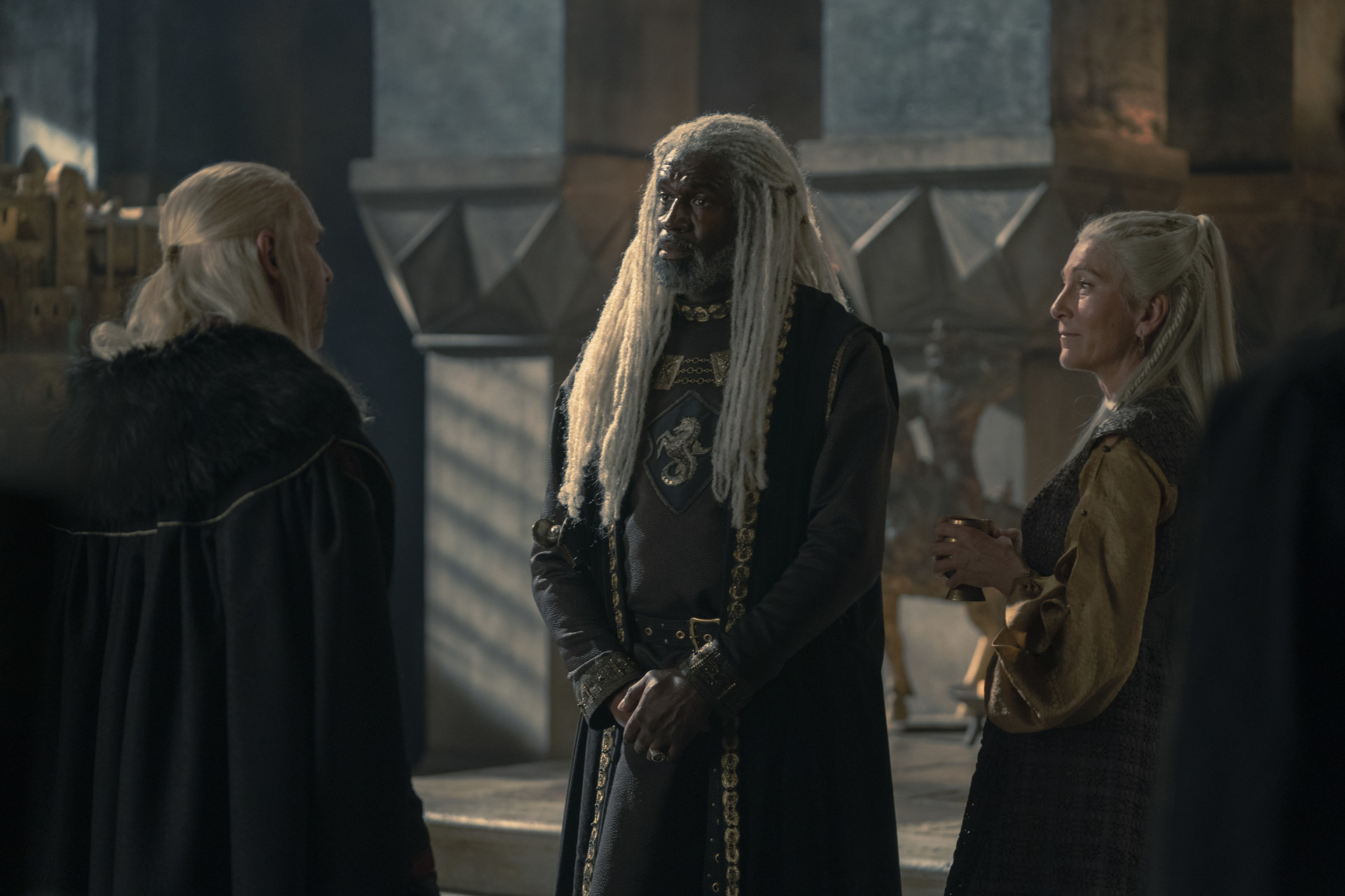 Viserys, Corlys and Rhaenys stand in the Hall of Nine