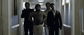 A group of four men walking down the hall