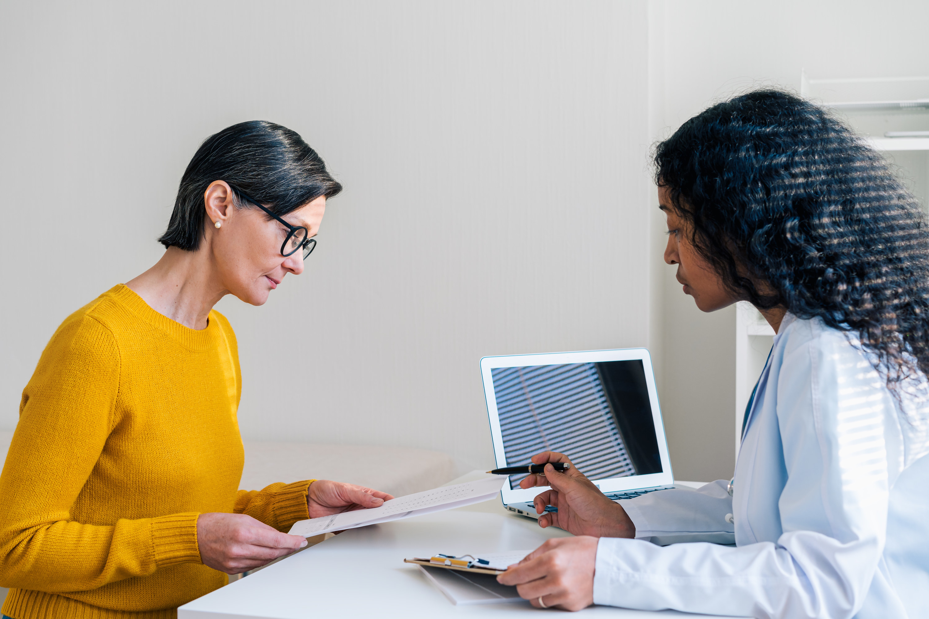 a woman talking to a doctor at their office