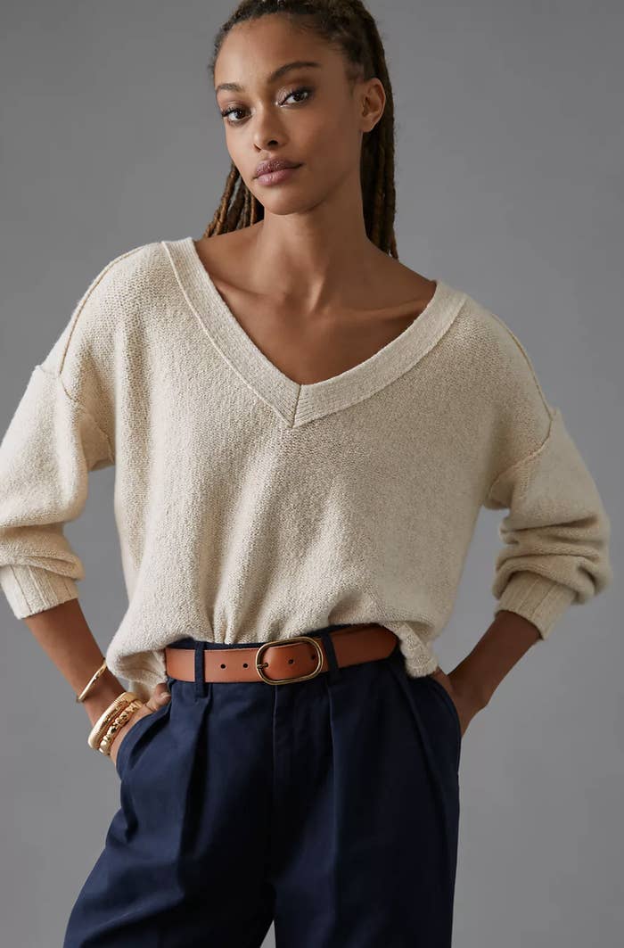 model wearing tan v-neck sweater