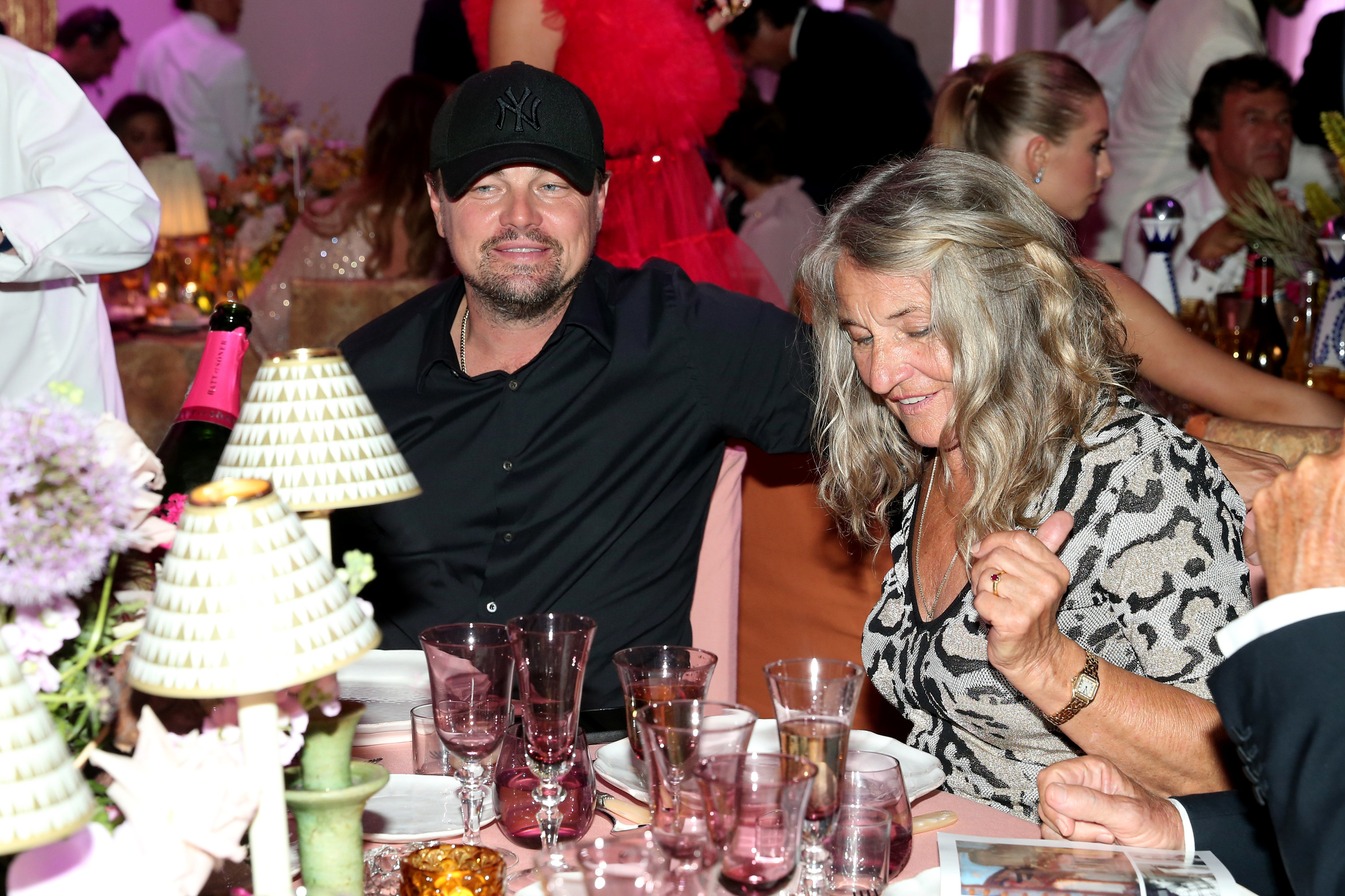 Leo wearing a cap and sitting at a table with his mother