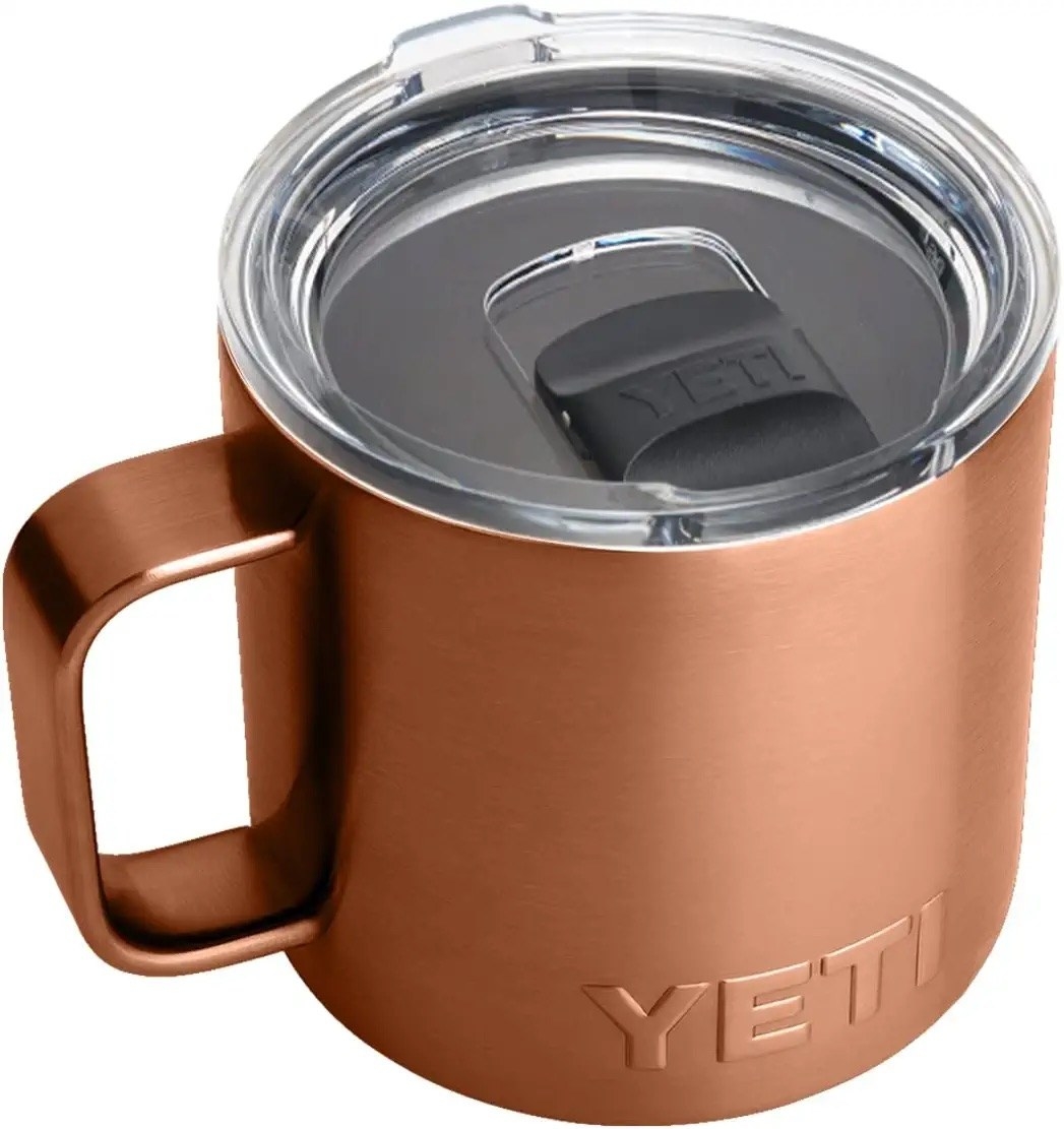 A copper-colored, short travel mug with an angular handle and a clear lid