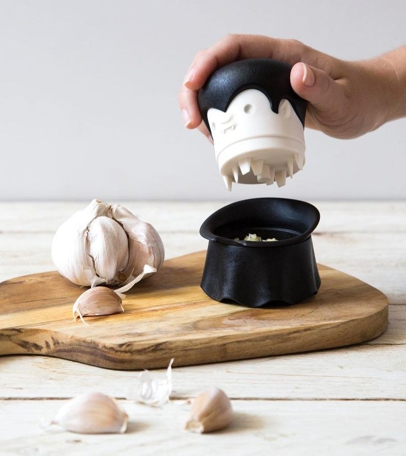 a person mincing garlic with the dracula shaped gadget