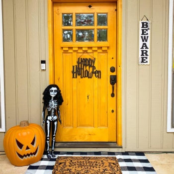 Reviewer's door mat is shown outside a Halloween themed front door