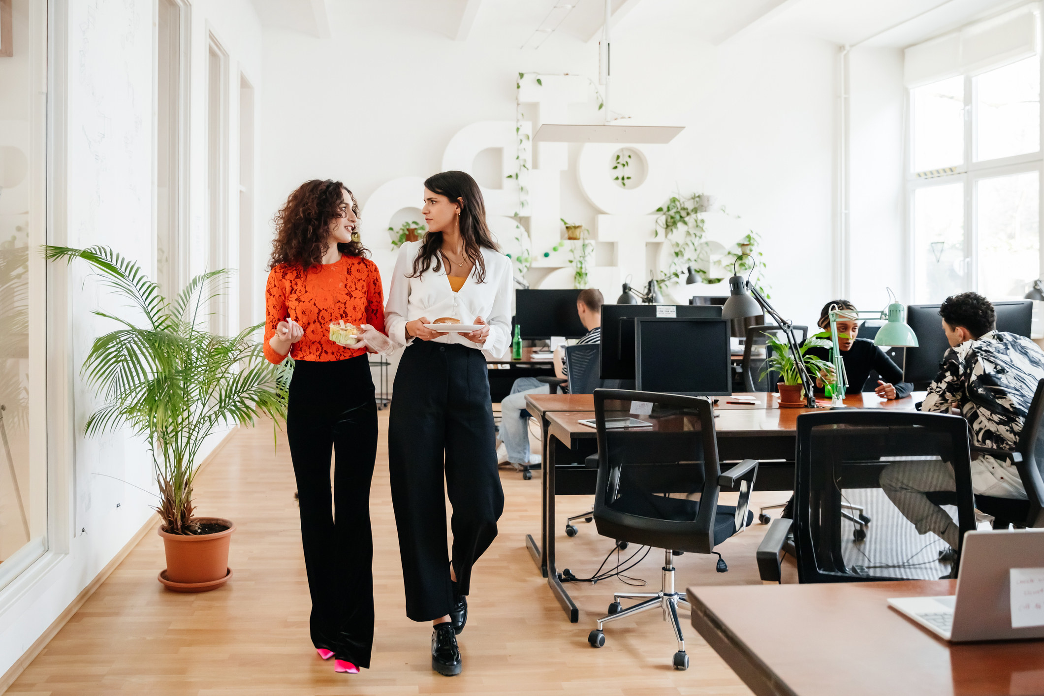 two women walking together in an office
