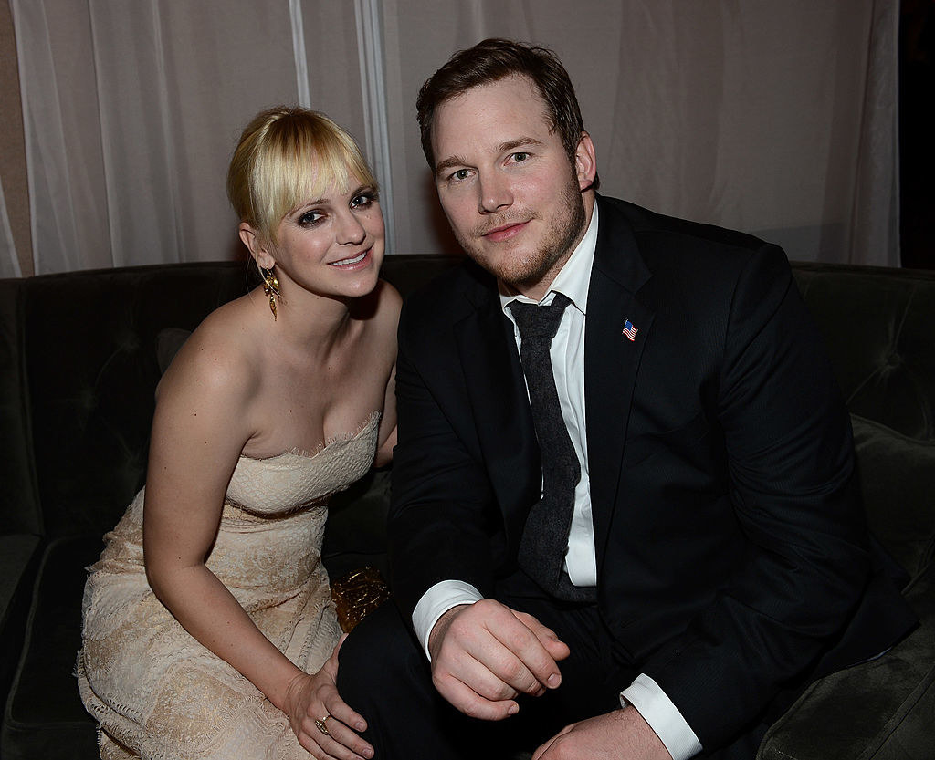 Chris in a suit and sitting with Anna Faris