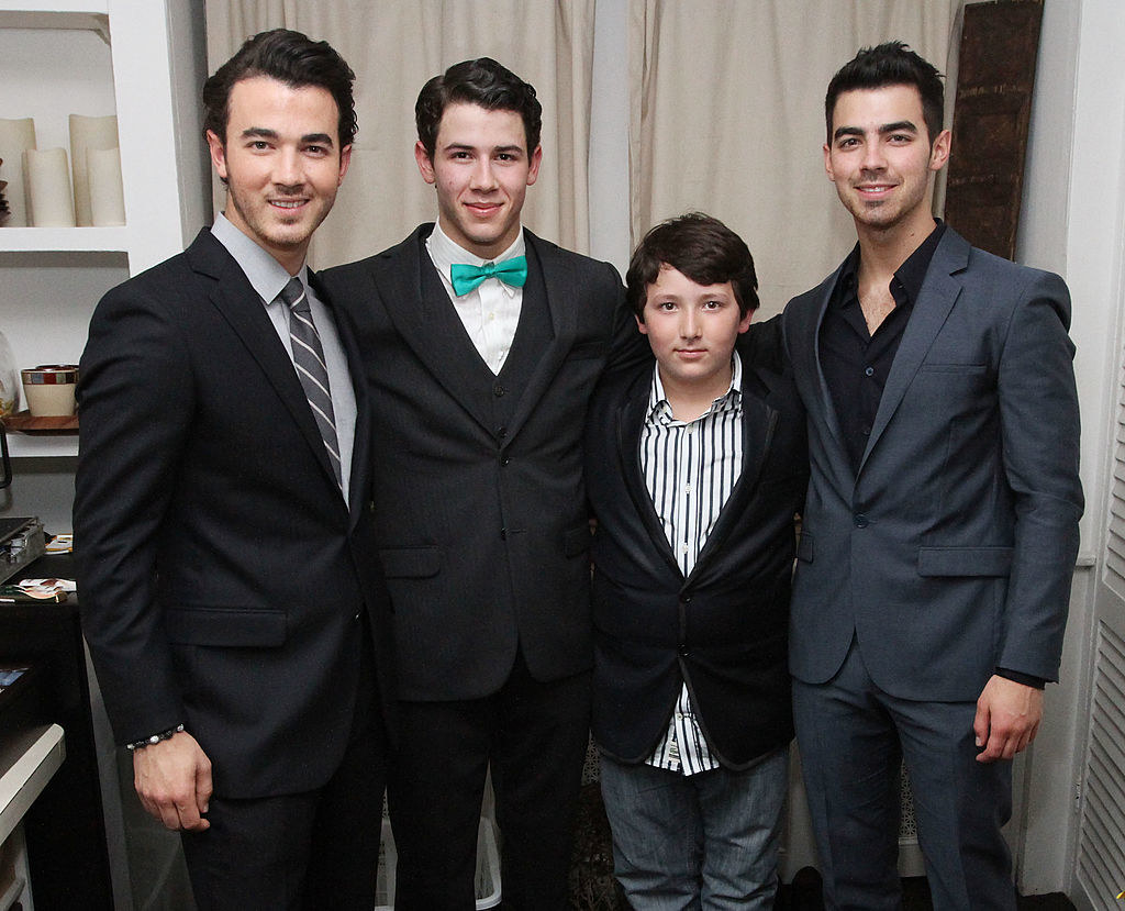 With his brothers, the Jonas Brothers, in suits