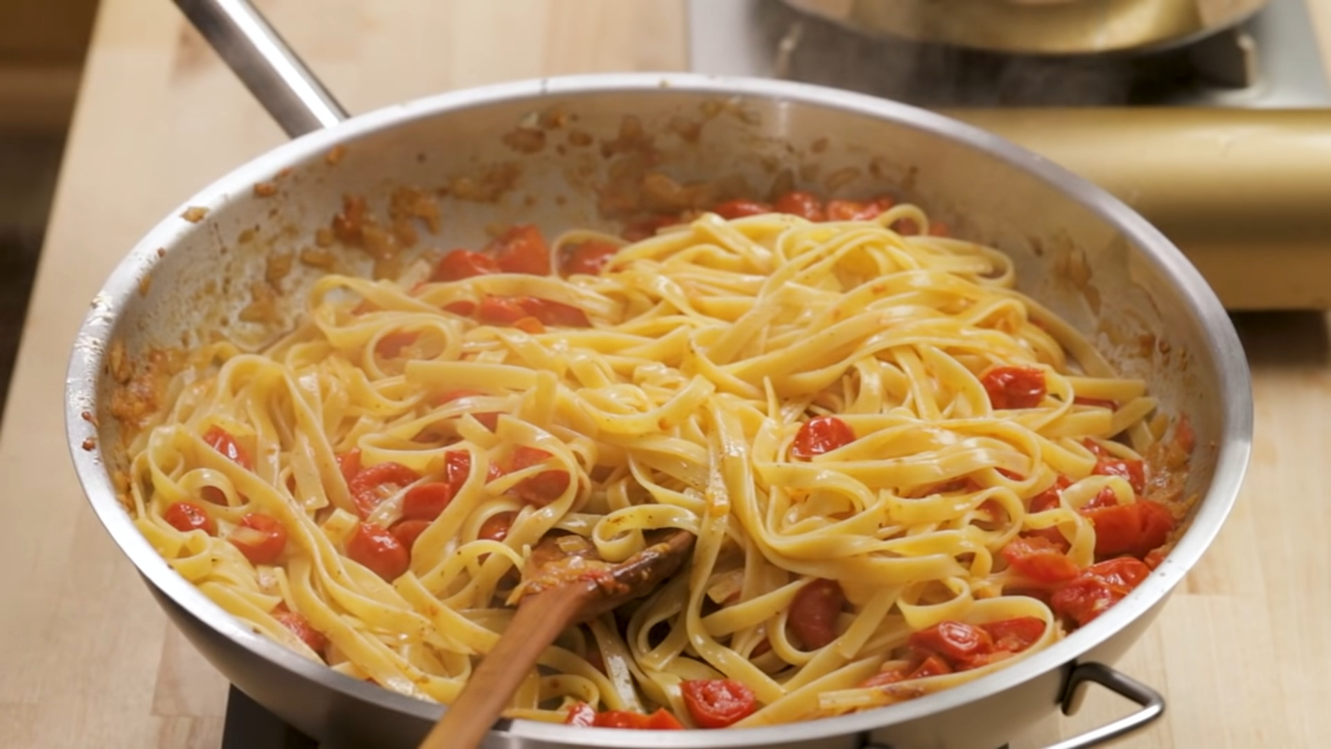 butter pasta with tomatoes in a pan