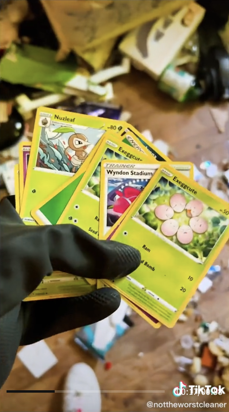 Brogan holding Pokemon cards among the mess