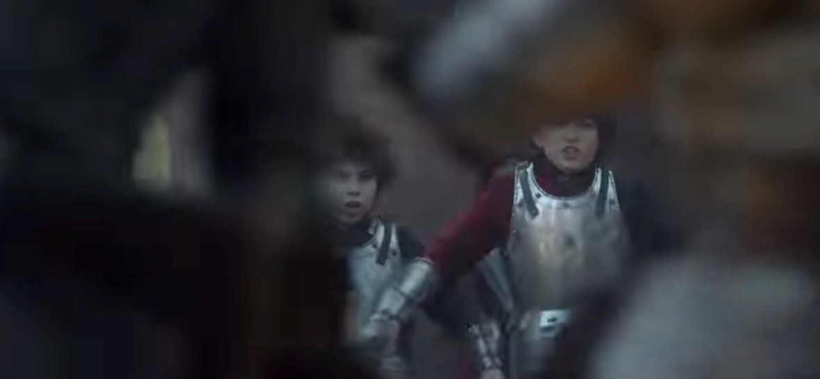 Two boys wearing armor look scared