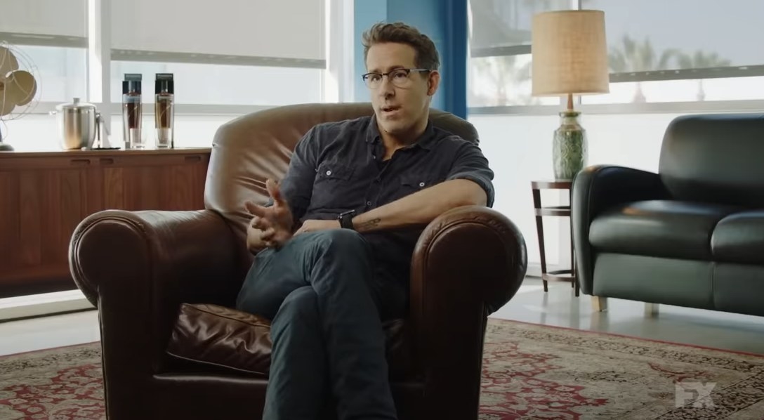 Ryan Reynolds sitting down speaking to someone