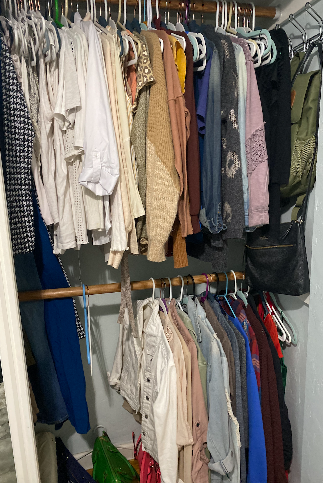 Shirts, sweaters, and other tops hanging in a two-level closet