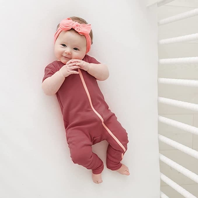 a baby in a crib wearing a onesie