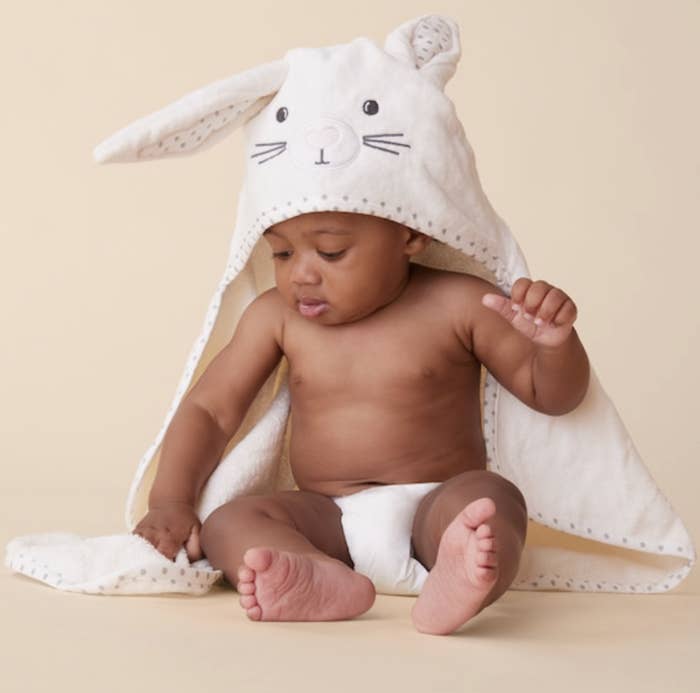 a baby wearing a towel that has a face and bunny ears on the hood