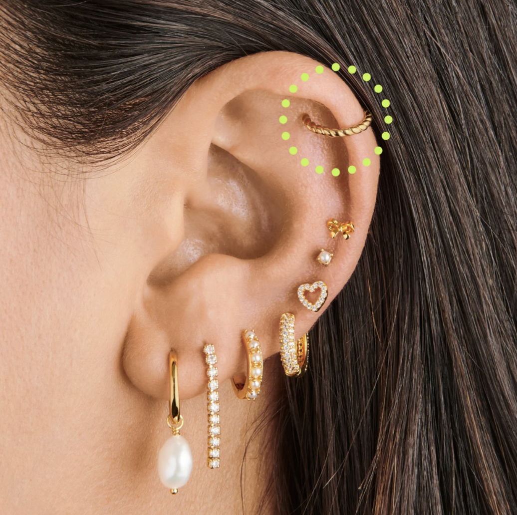 model wearing french twist earring cuff on ear amidst other earrings