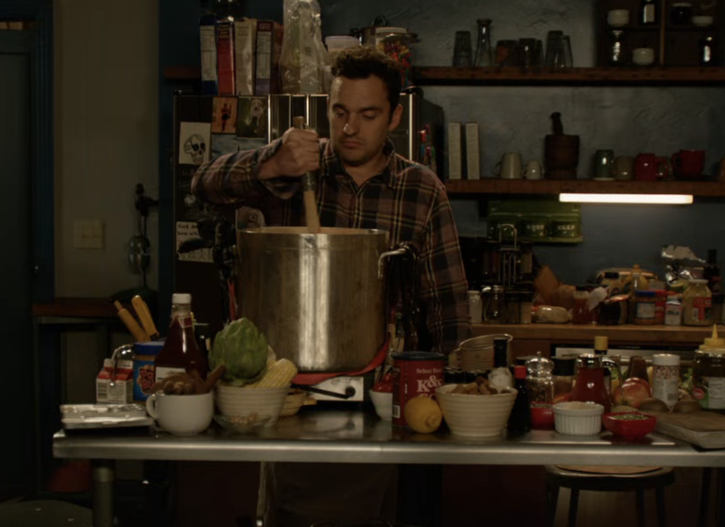 Nick stirring a pot in the kitchen with tons of ingredients on the counter around him