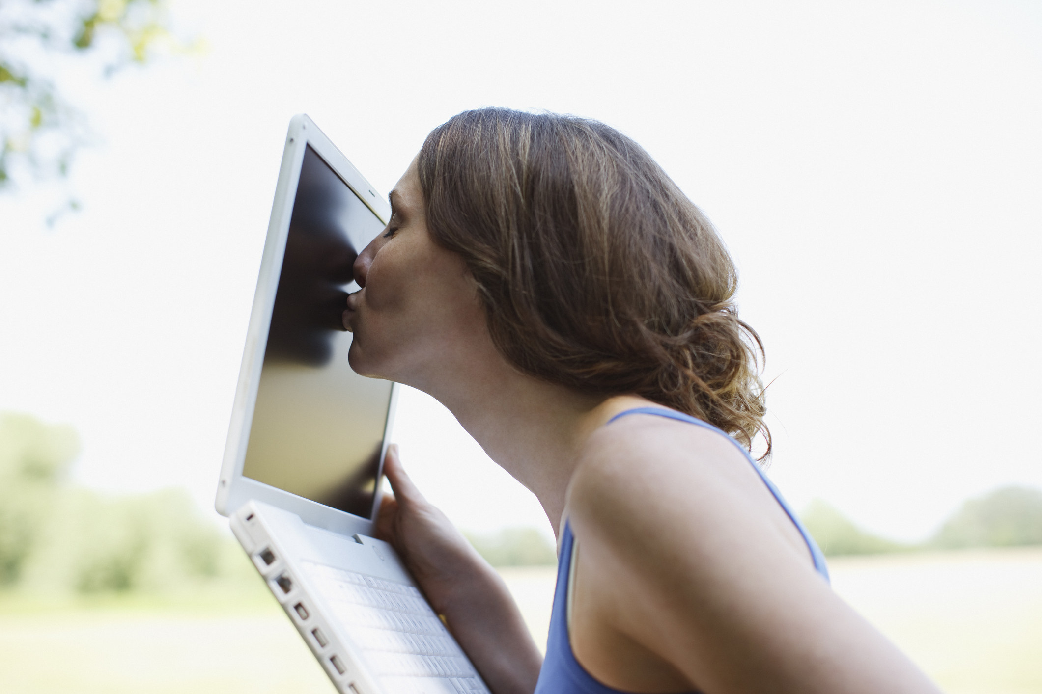 Woman kissing the screen of a laptop