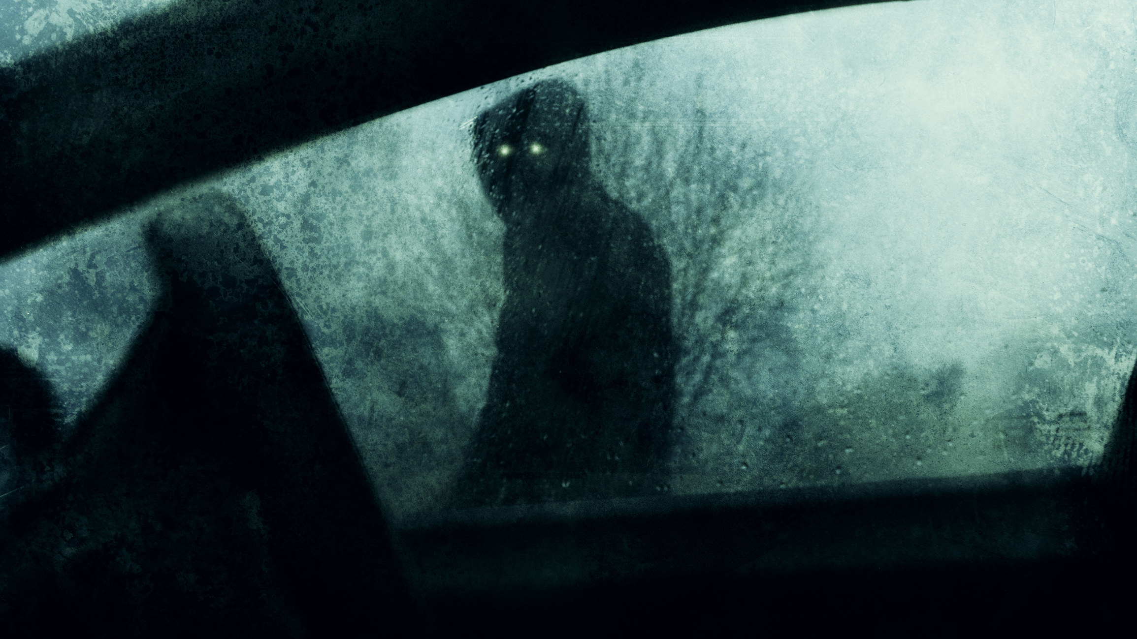 A dark figure outside of a car