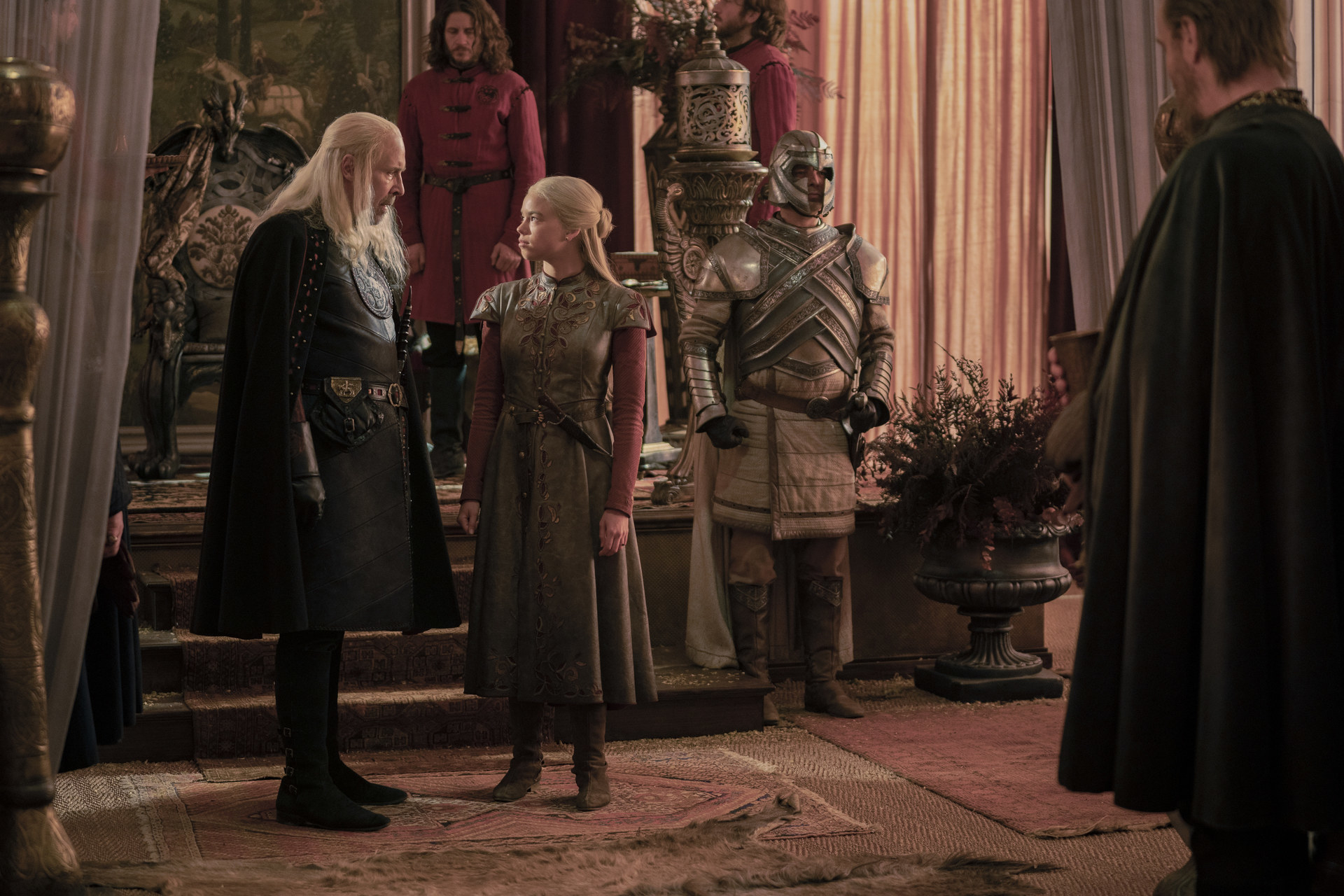 Rhaenyra and Viserys talk in their camp — perhaps of marriage — while Otto Jightower looks on.