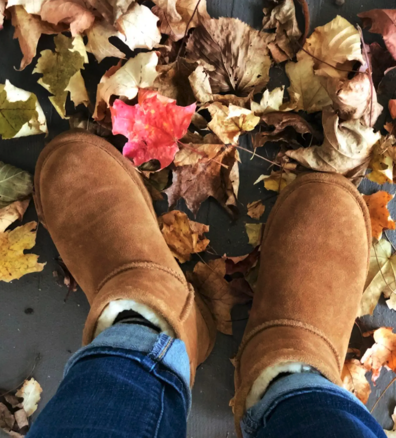 a reviewer wearing the boots in a leaf pile.