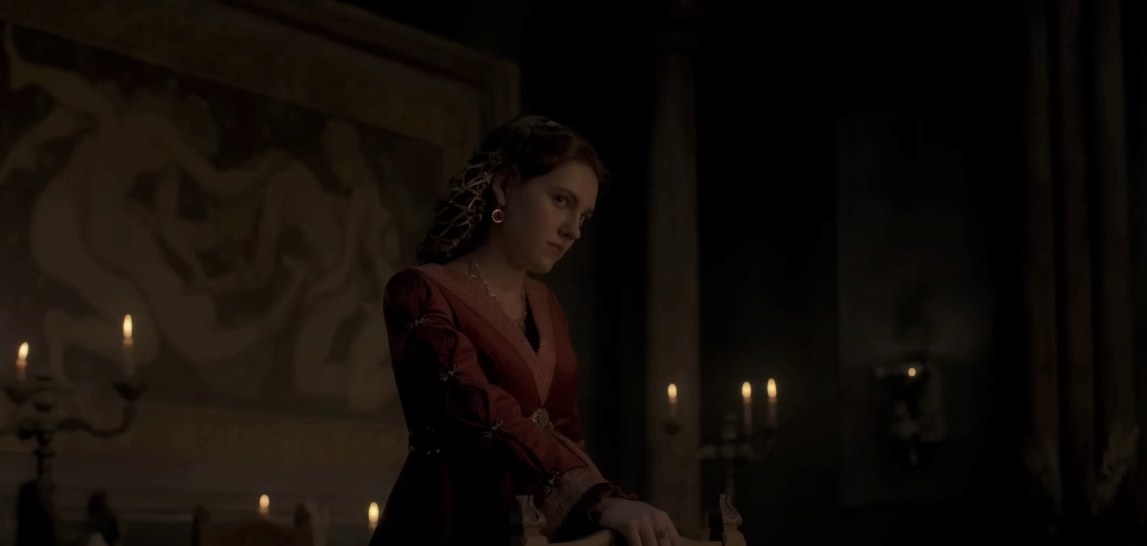 Alicent stands in her chamber wearing a red gown and looking serious