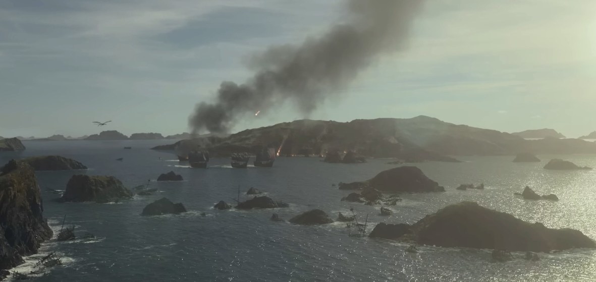 Smoke and fire above ships in a bay, with a dragon flying overhead