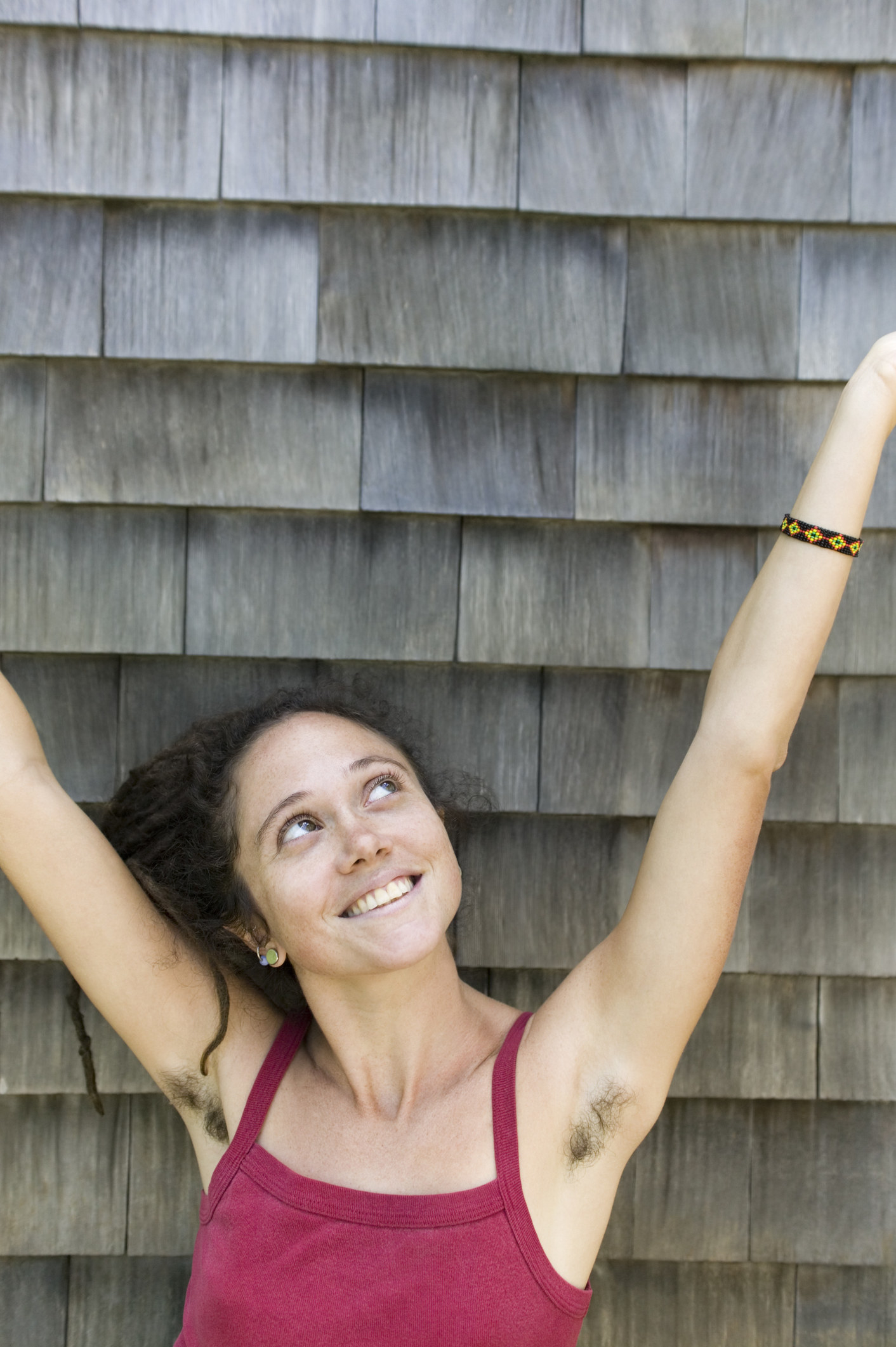 woman raising her arms to show off her armpit hair