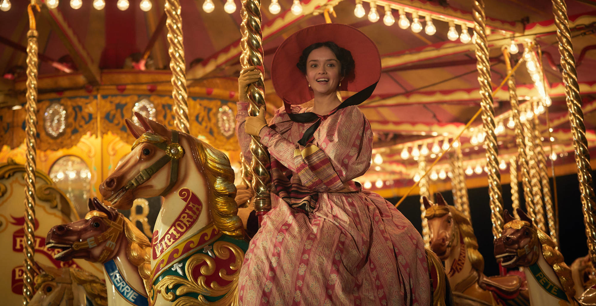 Olivia Cooke rides on a carousel