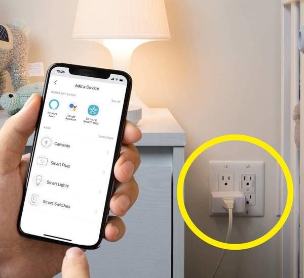a person holding their phone to use a smart plug