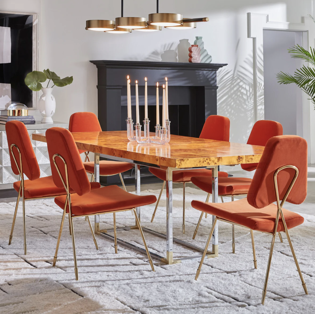 wood rectangle dining table with six orange chairs around it