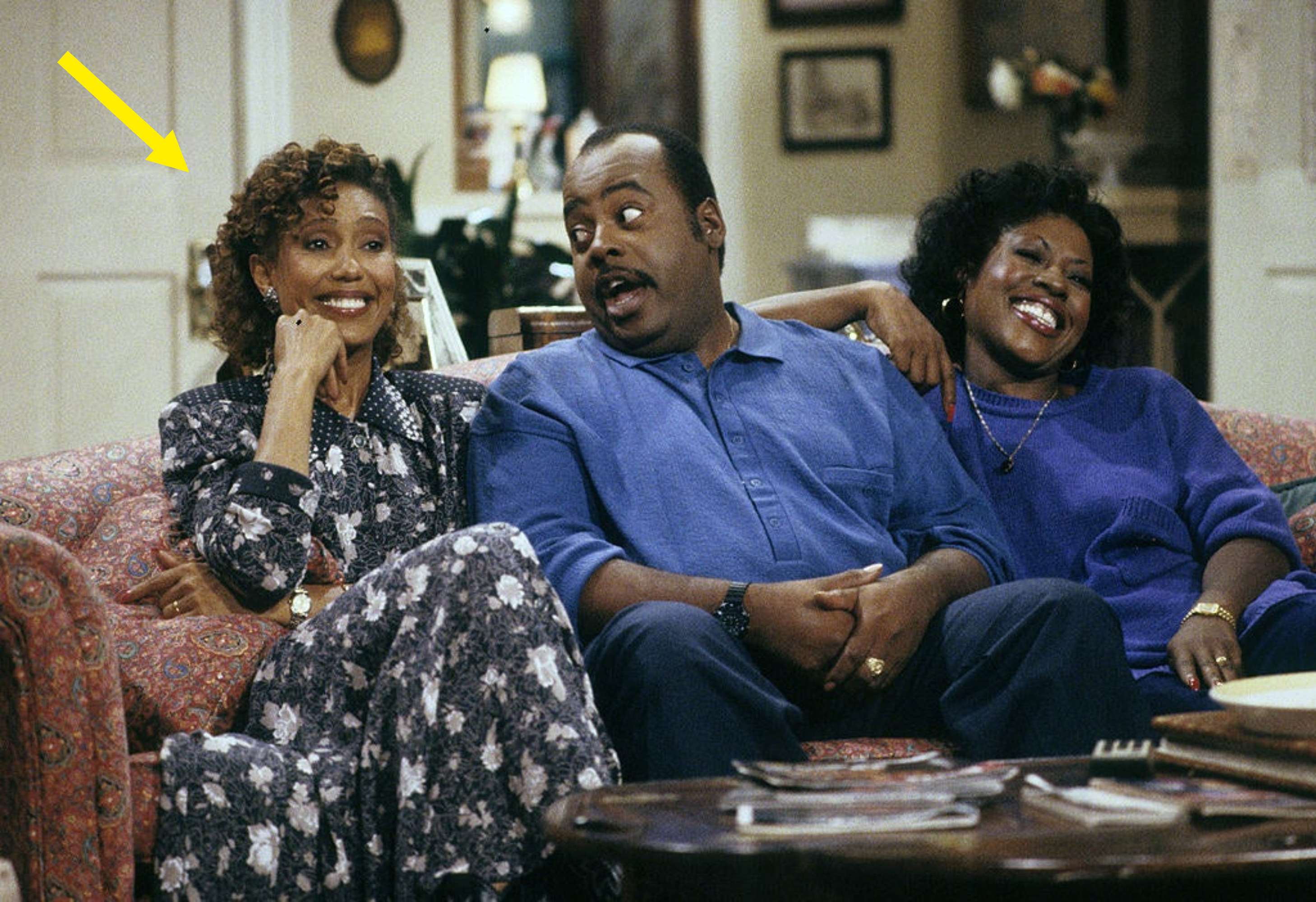 Arrow pointing to Telma in a scene from Family Matters sitcom sitting on a couch with Carl and Harriete Winslow