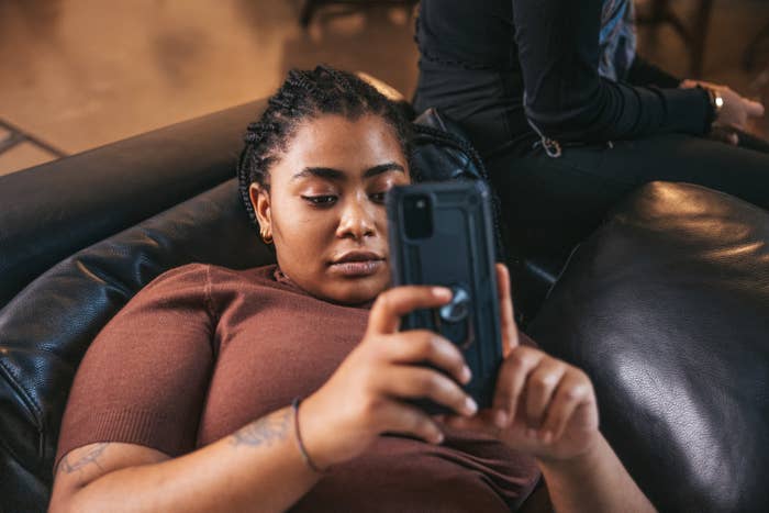 a woman on the couch on her phone