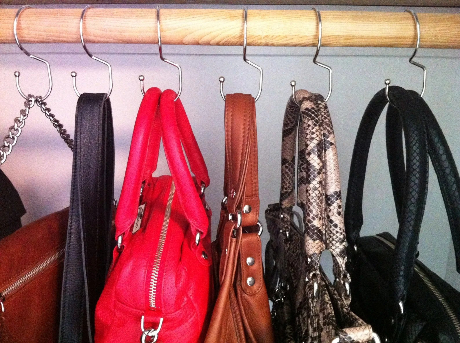 A reviewer's handbags hung on the handbag hangers