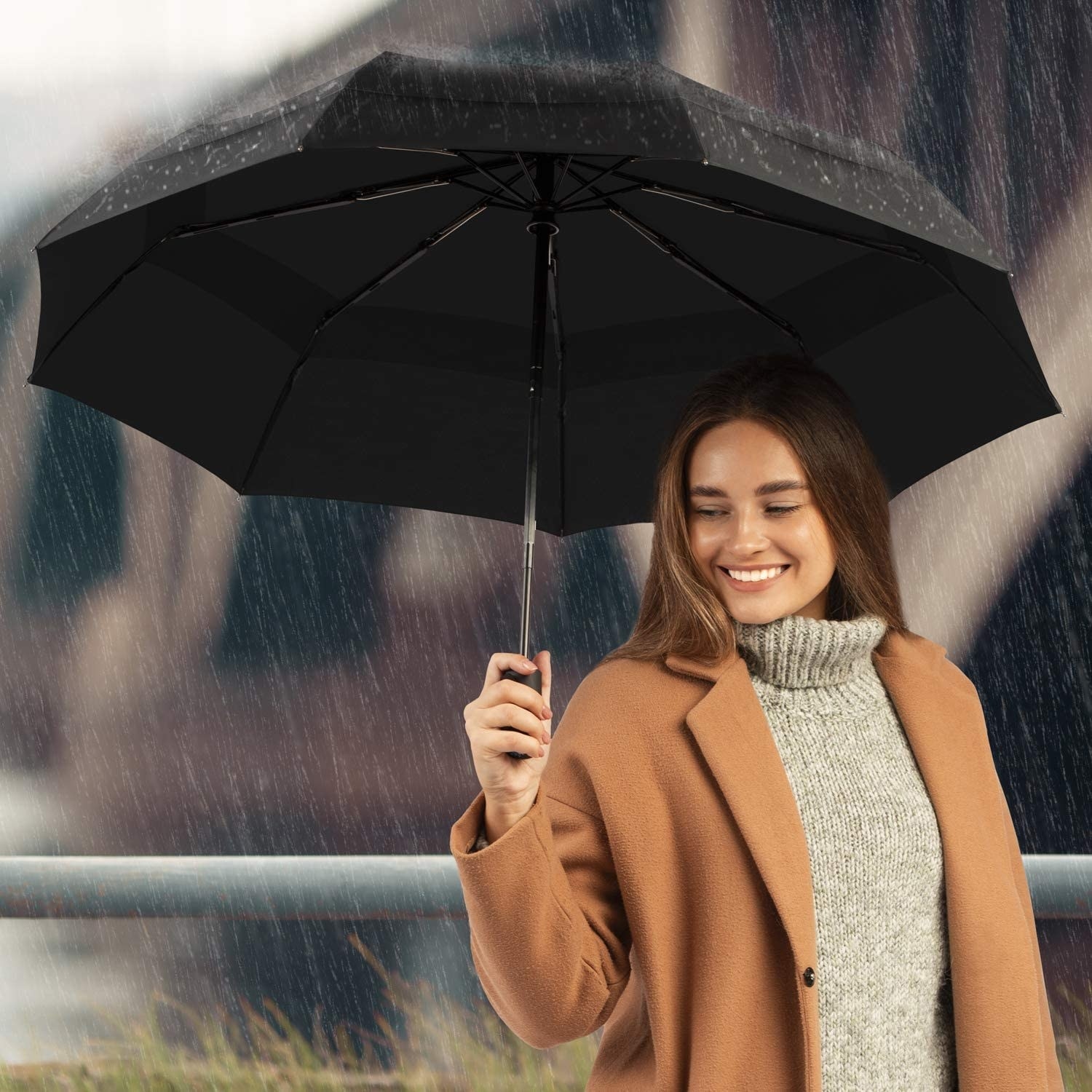 A person holding the umbrella in the rain